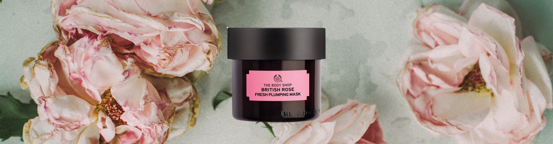 Photo of a jar of Body Shop British Rose Face Mask over a background of pink roses.